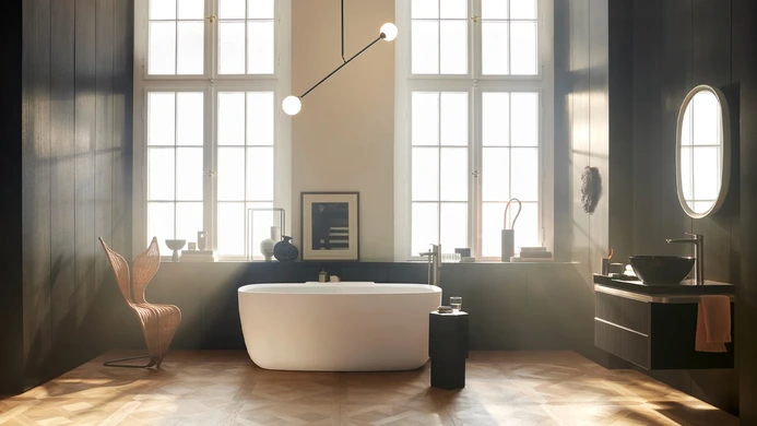 Wide angle shot of a large freestanding bath tub in a brightly lit bathoom