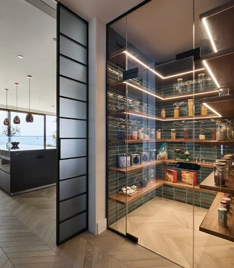 Rimadesio Soho glass door on a flush-fit ceiling rail above herringbone flooring